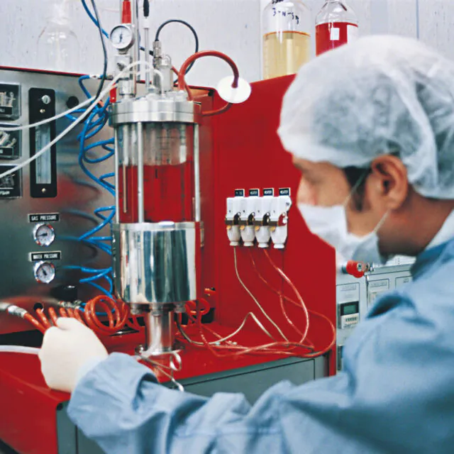 Scientist in a lab with red equipment